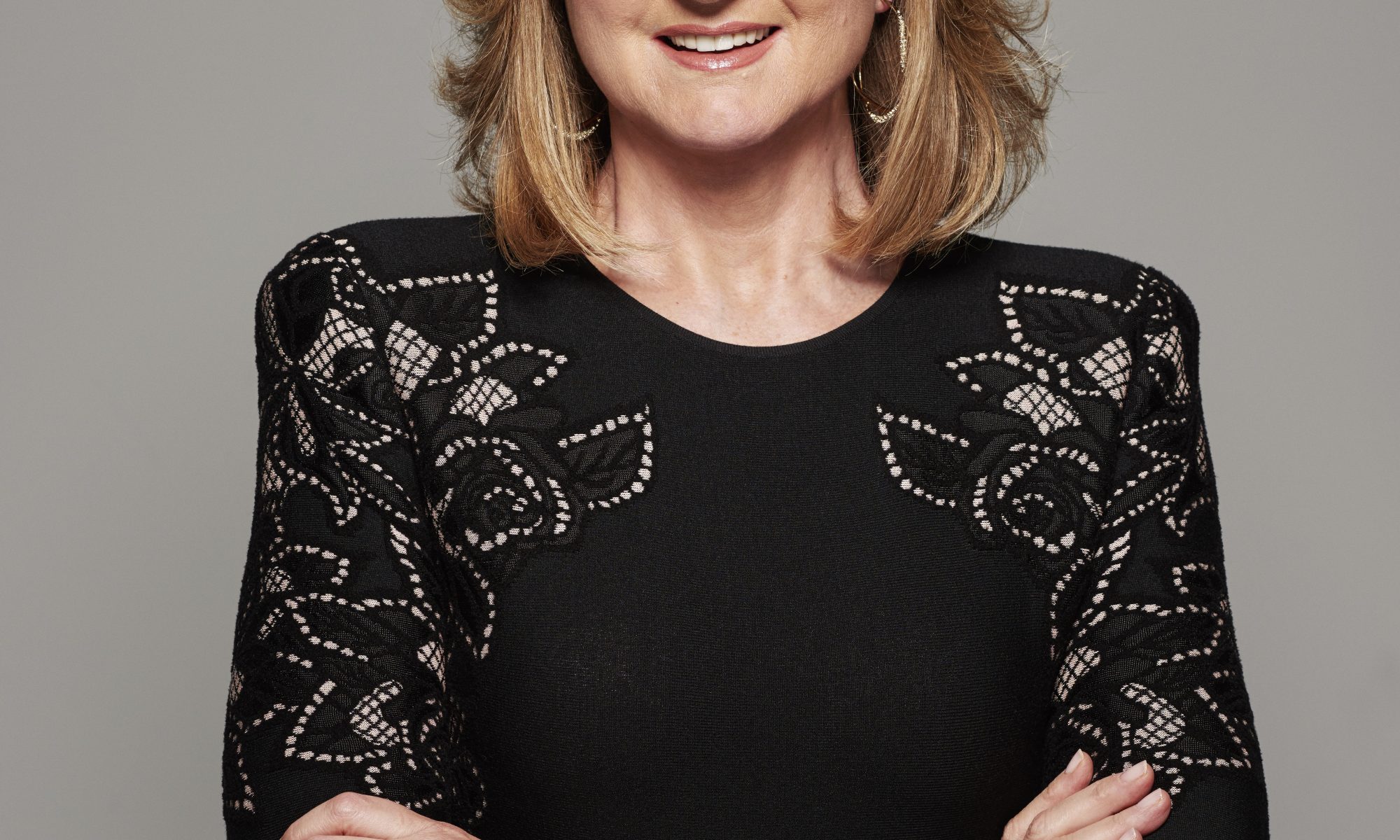 Arianna Huffington in front of a gray backdrop.